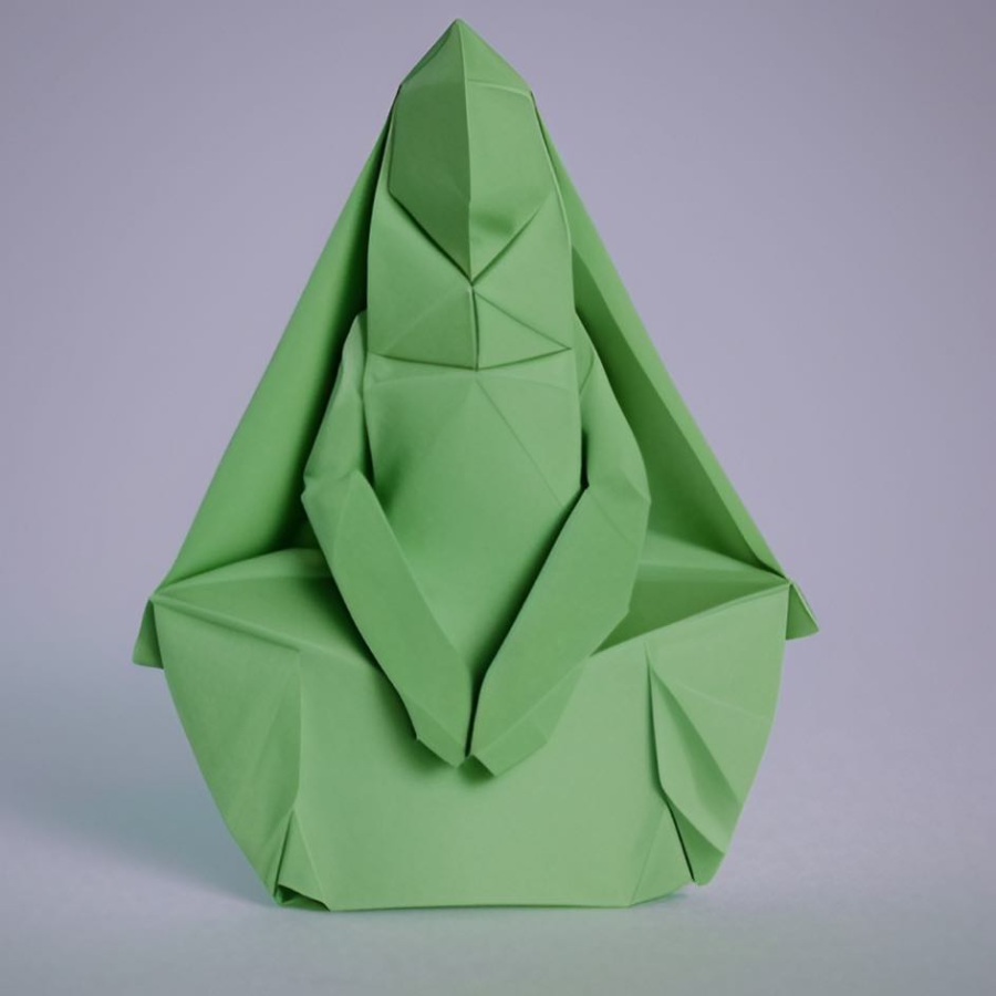 origami green paper in shape of meditating person